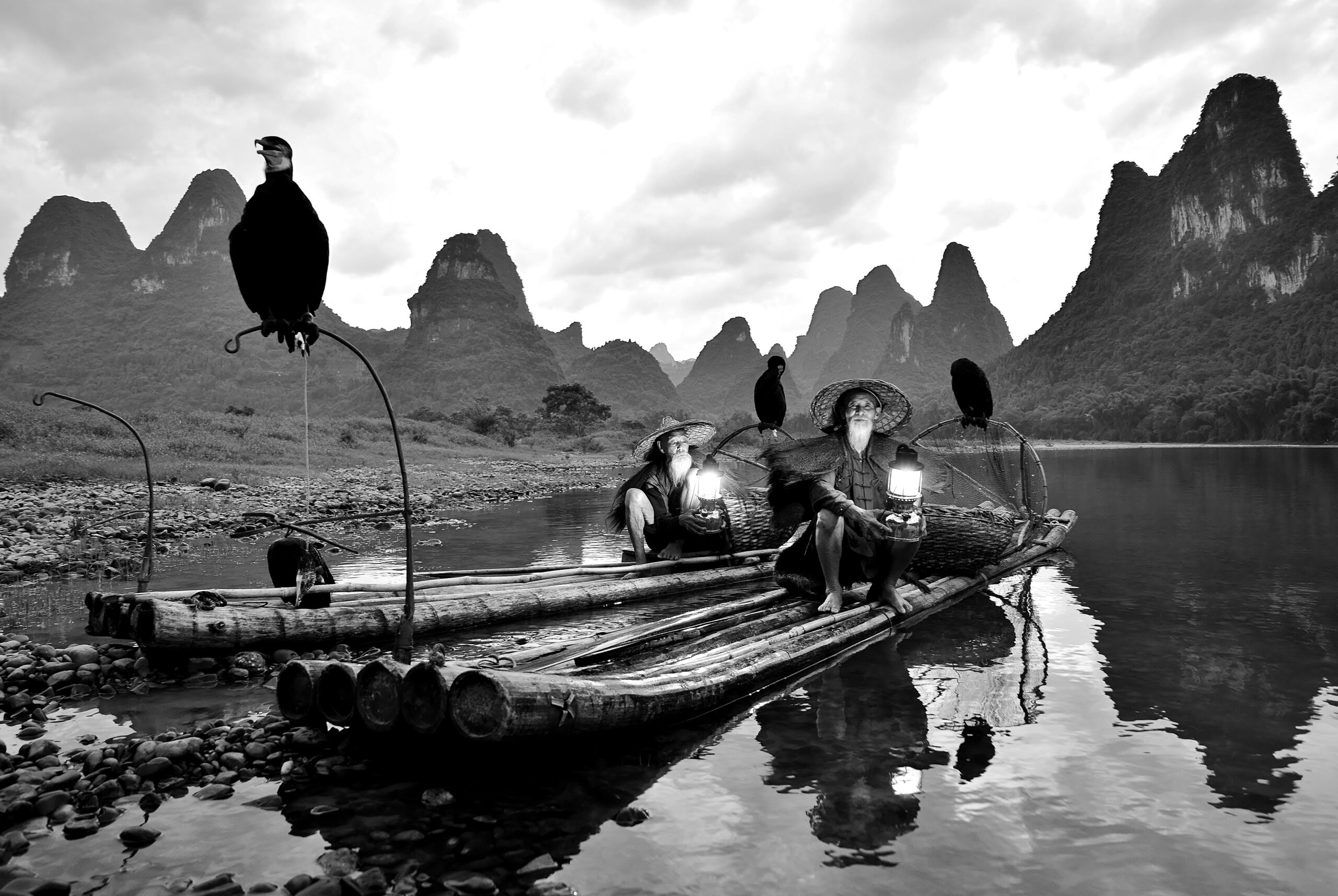 Cormorant fisherman brothers Huang in sunset at Li River, Yangshuo, Guangxi, China