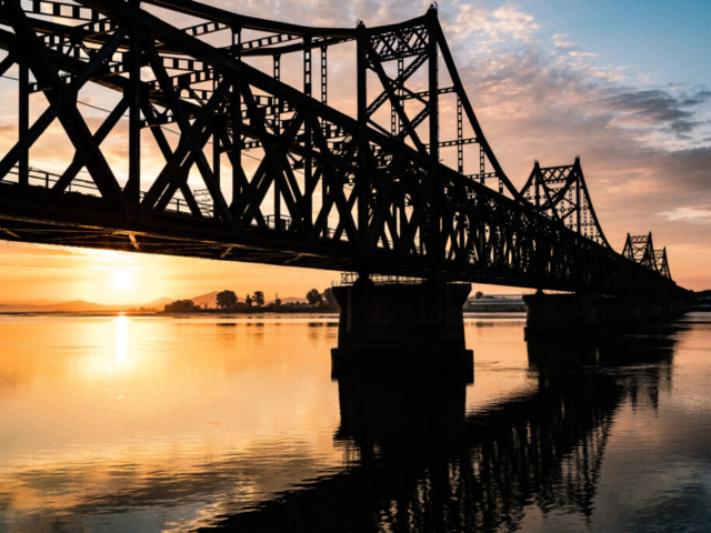 China Korea Friendship Bridge over Yalu River at border in sunrise, Dandong, Liaoning, China//Xinuiju, North Korea (DPRK)